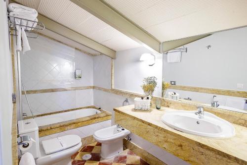 a bathroom with a white toilet and a sink at Labreña Hotel in Los Caños de Meca
