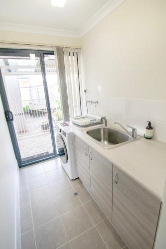a kitchen with a sink and a washing machine at Lakeside Living in Cuthbert