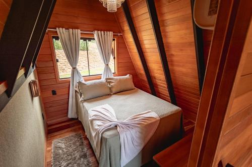 een klein bed in een kamer met een raam bij Kleines Paradies Chalés in Massaranduba