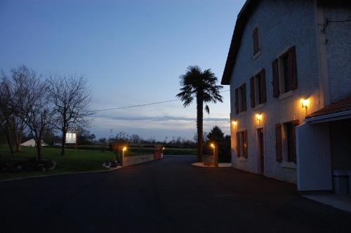 a house with a palm tree and a building with lights at L'Horizon des Landes in Doazit