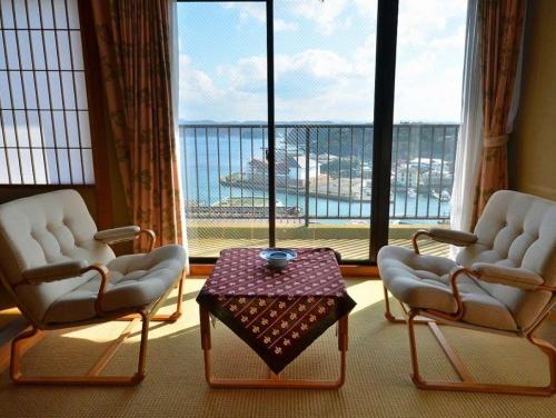 two chairs and a table in a room with a large window at Kishotei - Vacation STAY 76550v in Hirado