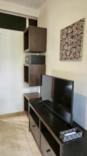 a living room with a tv and a black desk at Eco del Mar in La Libertad