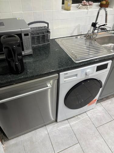 a kitchen with a washing machine and a sink at Cosy room 4 s in Streatham Vale