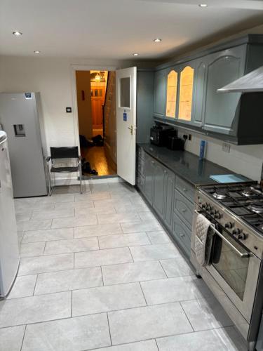 a kitchen with gray cabinets and a tile floor at Cosy room 4 s in Streatham Vale