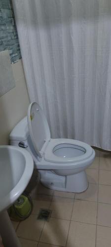 a bathroom with a white toilet and a sink at Florida sun condo in Dasmariñas