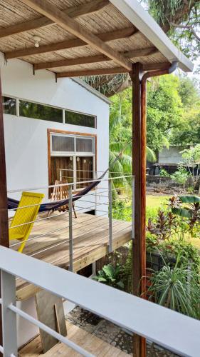 a porch with a yellow chair on a wooden deck at Eco del Mar in La Libertad