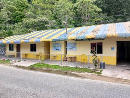 a yellow building with a blue and yellow roof at kieara Redang Chalet in Kampong Pinang