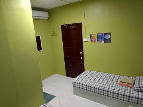 a small bedroom with a bed and a door at kieara Redang Chalet in Kampong Pinang