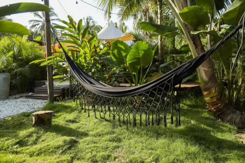 a hammock hanging from a tree in a garden at Nómada Tayrona Boutique Glamping in Santa Marta