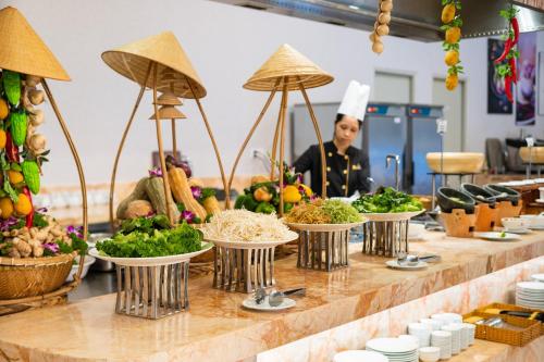a chef standing behind a counter with bowls of food at DIC Star Landmark in Vung Tau