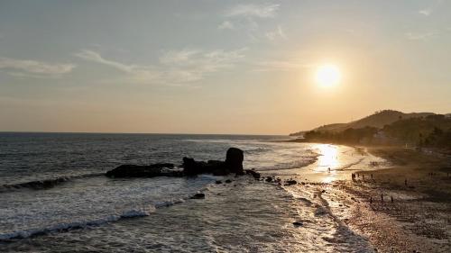 a beach with the sun rising over the ocean at Eco del Mar in La Libertad