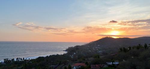 a sunset over the ocean with a mountain at Eco del Mar in La Libertad