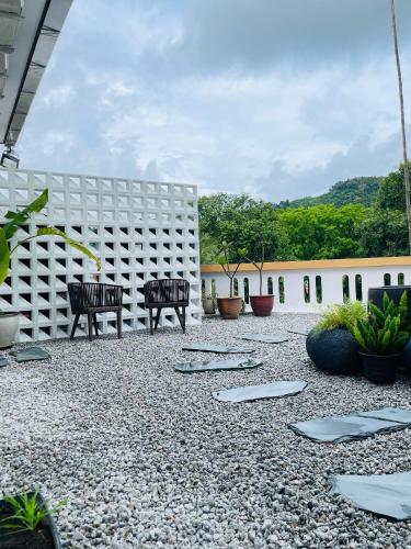 a courtyard with two benches and a building at BaBa Boutique House Langkawi in Pantai Cenang