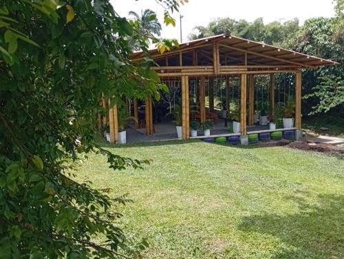 a wooden pavilion in a yard with grass at Finca Hostal La Esperanza in Quimbaya