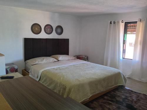 サン・トメー・ダス・レトラスにあるRecanto das Pedras - Mini Casaのベッドルーム1室(ベッド1台、壁に2皿)