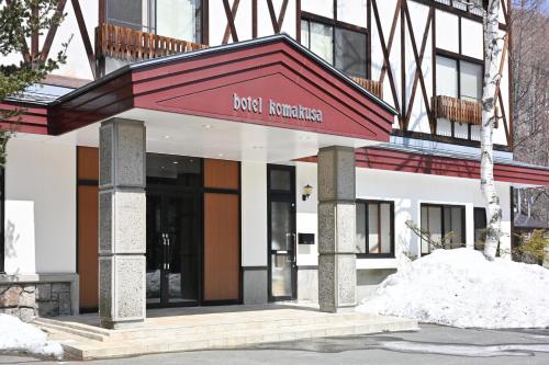 a building with a red awning in front of it at Komakusa Hotel in Matsumoto