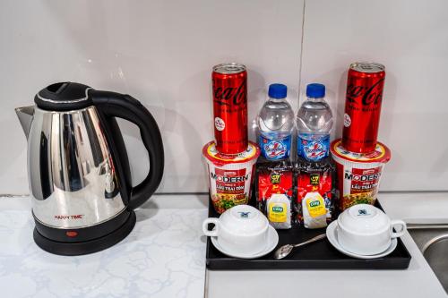 a counter top with soda cans and a tea kettle at Lotus Lalala Inn Hotel in Ho Chi Minh City