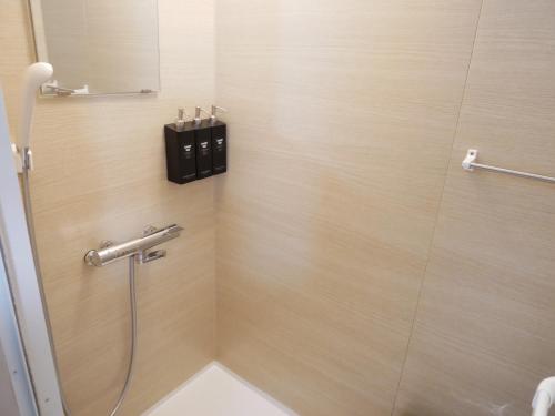 Un baño con ducha con una caja negra en la pared. en HOOD - Vacation STAY 19649v, en Amami