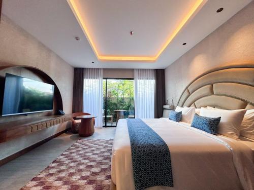a bedroom with a large bed and a television at TUI BLUE Berawa Hotel and Villas in Canggu