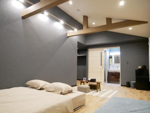 a bedroom with a white bed and a blue wall at HOOD - Vacation STAY 19686v in Amami