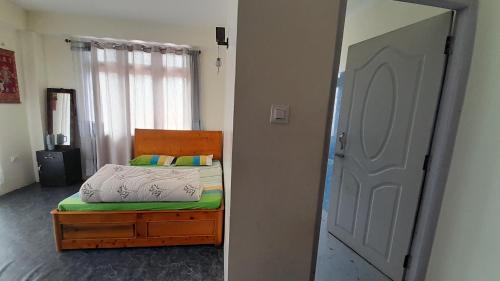 a bedroom with a bed and a door with a mirror at Mountain Majesty Homestay, Sombaria in Sombāri