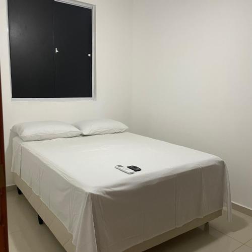 a bed in a room with a tv on the wall at Descanso e lazer in Parnamirim