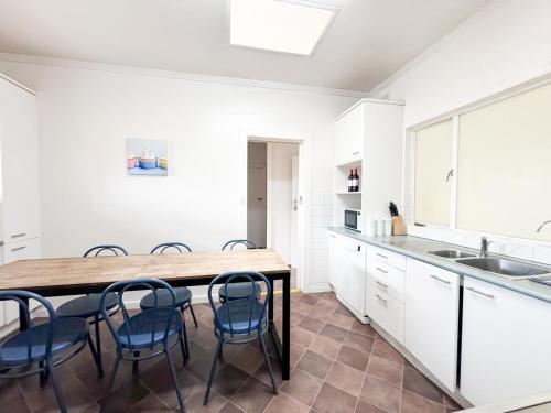a kitchen with a wooden table and blue chairs at big group entire house 15 beds in Sleeps Hill Station