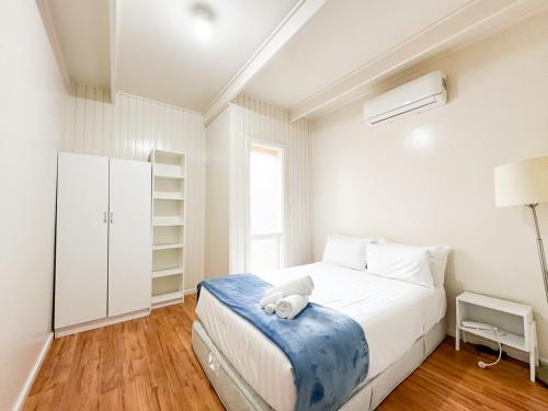 a white bedroom with a bed and a window at big group entire house 15 beds in Sleeps Hill Station