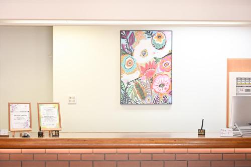 a wall with a picture of flowers on it at Komakusa Hotel in Matsumoto