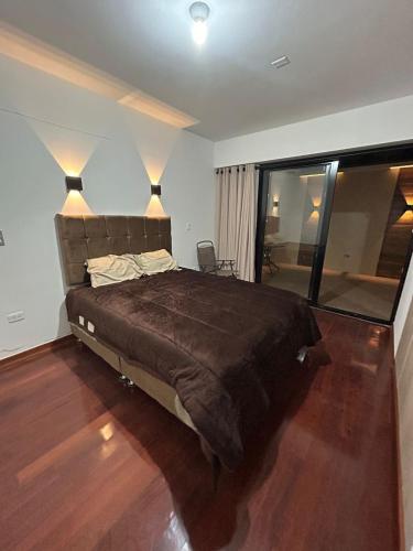 una camera da letto con un letto grande e una grande finestra di Golden Magisterio a Cuzco