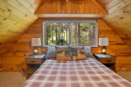 a bedroom with a bed in a log cabin at Rainier's Iconic Cabin with Forest Views & Hot Tub in Ashford