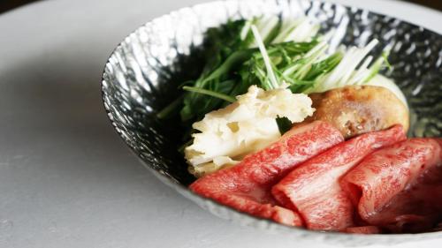 a bowl of food with meat and vegetables on a table at Hotel Kikori in Hida