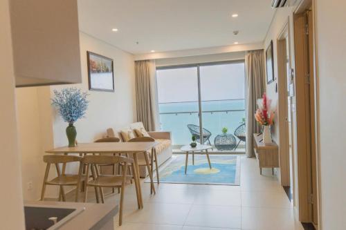 a living room with a table and a couch at Monica Homestay - Căn hộ The Song Vũng Tàu in Vung Tau