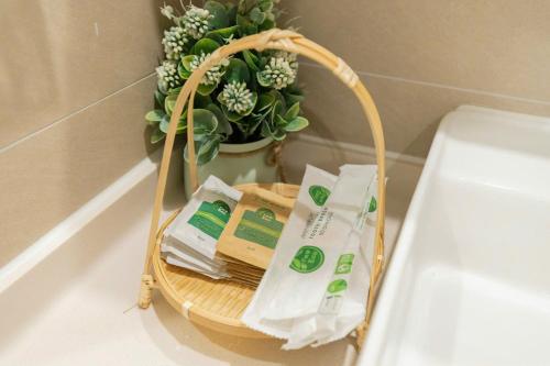 a basket with toilet paper and a plant in a bathroom at Monica Homestay - Căn hộ The Song Vũng Tàu in Vung Tau