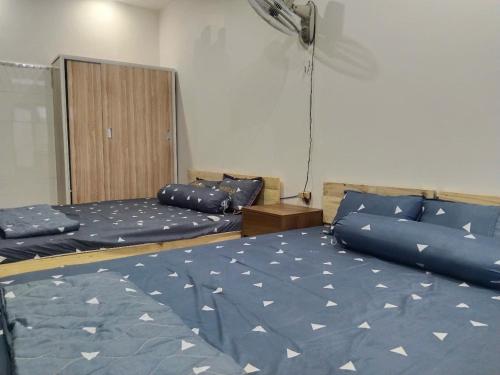 a bedroom with two beds with blue sheets and a cabinet at Vũ Gia Homestay in Ấp Bình Thạnh