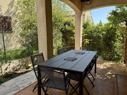 une table noire et des chaises sur une terrasse dans l'établissement Maison avec jardin et terrasse, 3 chambres à Sète - FR-1-338-612, à Sète