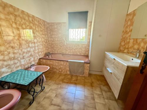 La salle de bains est pourvue de 2 lavabos, d'une baignoire et d'un lavabo. dans l'établissement Maison avec jardin et terrasse, 3 chambres à Sète - FR-1-338-612, à Sète