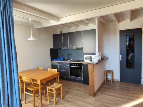 une cuisine et une salle à manger avec une table et des chaises dans l'établissement Appartement au Cœur de Super Besse avec Balcon et Parking - FR-1-814-98, à Besse-et-Saint-Anastaise