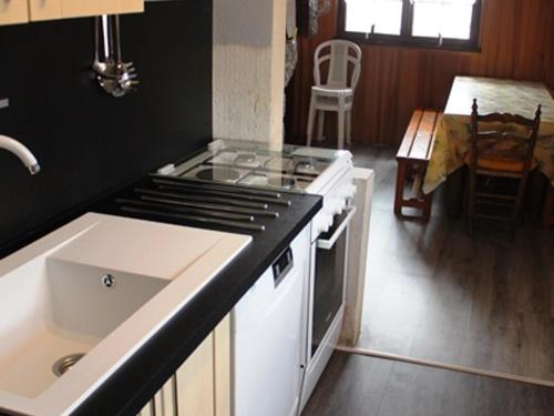 a kitchen with a stove top oven next to a sink at Chalet Calme sur les Hauteurs - 8 Pers, Proche Pistes - FR-1-814-103 in Besse-et-Saint-Anastaise