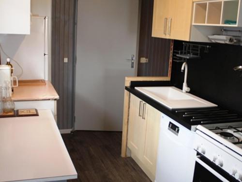 une cuisine avec un évier et une cuisinière four supérieur dans l'établissement Chalet Calme sur les Hauteurs - 8 Pers, Proche Pistes - FR-1-814-103, à Besse-et-Saint-Anastaise