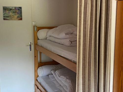 Zimmer mit 2 Etagenbetten und einem Vorhang in der Unterkunft Studio central proche remontées mécaniques - FR-1-814-117 in Besse-et-Saint-Anastaise