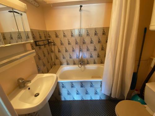 ein Badezimmer mit Badewanne, Waschbecken und Toilette in der Unterkunft Studio central proche remontées mécaniques - FR-1-814-117 in Besse-et-Saint-Anastaise