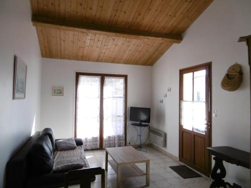 - un salon avec un canapé et un plafond en bois dans l'établissement Maison de campagne à L'Épine pour 4 personnes - FR-1-823-146, à LʼÉpine