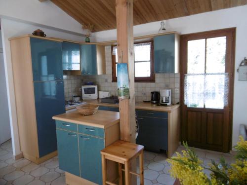 une cuisine avec des armoires bleues et un comptoir dans l'établissement Maison de campagne à L'Épine pour 4 personnes - FR-1-823-146, à LʼÉpine