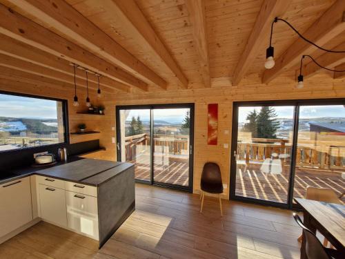 Il comprend une cuisine dotée de plafonds en bois et de grandes fenêtres. dans l'établissement Chalet familial moderne à Super Besse pour 14 pers. - FR-1-814-121, à Besse-et-Saint-Anastaise