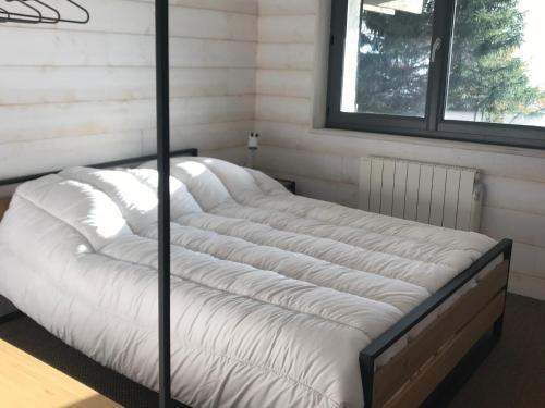 a bed in the corner of a room at Chalet rénové pour 10 pers. avec Parking proche Super Besse - FR-1-814-102 in Besse-et-Saint-Anastaise