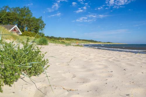 a sandy beach with a house and the ocean at Apple Blossom Studio - near Rønne and Beach in Rønne
