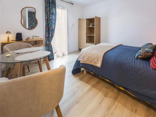 a bedroom with a bed and a table and chairs at Chambre cosy avec terrasse privative et wifi à Missillac - FR-1-306-1306 in Missillac