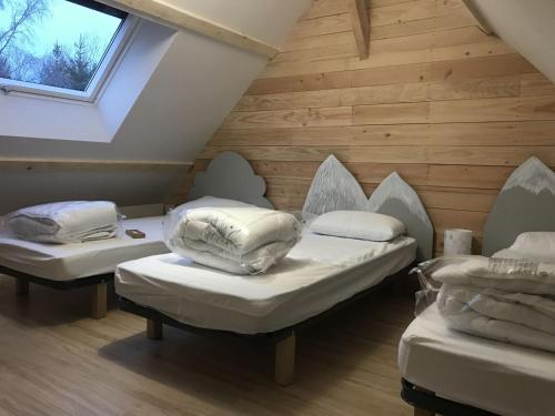 une chambre mansardée avec deux lits et une fenêtre dans l'établissement Chalet spacieux 170m2, jusqu'à 14 pers., lumineux salon et terrasse - FR-1-814-105, à Besse-et-Saint-Anastaise