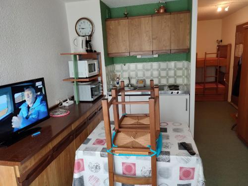 une cuisine avec une télévision et une chaise dans l'établissement Studio bien équipé près des pistes à Super Besse - FR-1-814-113, à Besse-et-Saint-Anastaise